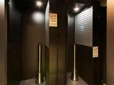 a pair of elevators in a building with signs at Villa Fontaine Tokyo Hatchobori in Tokyo