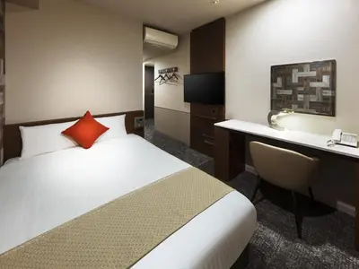 a hotel room with a bed and a desk at Villa Fontaine Tokyo Hatchobori in Tokyo