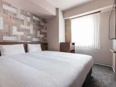 a hotel room with a large bed and a window at Villa Fontaine Tokyo Hatchobori in Tokyo