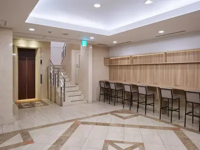a lobby with chairs and a staircase in a building at Villa Fontaine Tokyo Jimbocho in Tokyo