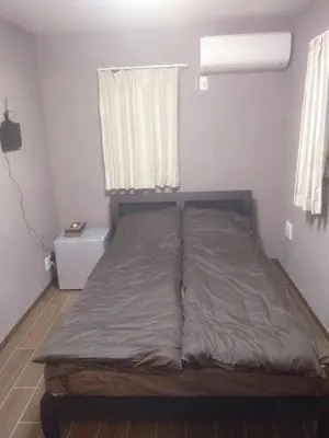 a bed in a small room with a window at Nice Hostel Yahiro in Tokyo