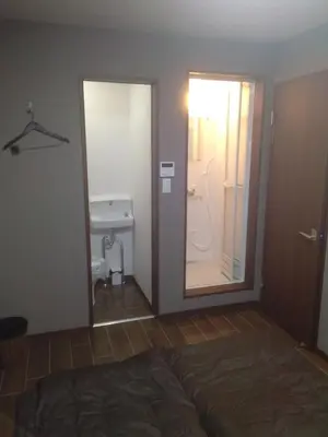 a bedroom with a door leading to a bathroom at Nice Hostel Yahiro in Tokyo