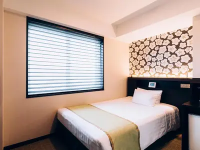 a small bedroom with a bed and a window at Shinagawa Tobu Hotel in Tokyo