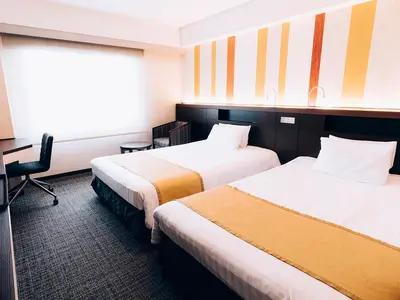 a hotel room with two beds and a desk at Shinagawa Tobu Hotel in Tokyo