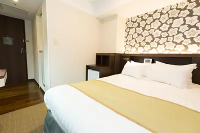 a hotel room with a large bed with white sheets at Shinagawa Tobu Hotel in Tokyo
