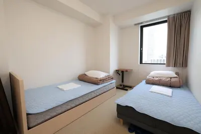 a bedroom with two beds and a window at Tokyo Ueno Youth Hostel in Tokyo