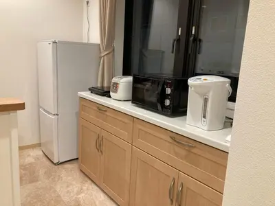 a kitchen with a counter with a refrigerator and appliances at Tokyo Ueno Youth Hostel in Tokyo