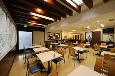 a restaurant with tables and chairs and a map on the wall at Smile Hotel Nihombashi Mitsukoshimae in Tokyo