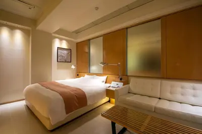 a hotel room with a bed and a bench at HOTEL APERTO (Adult Only) in Tokyo