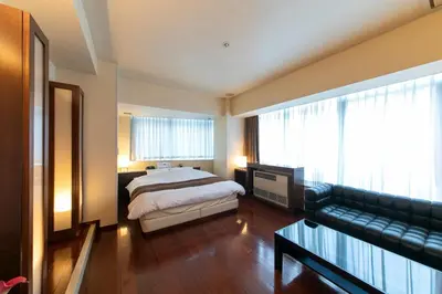 a bedroom with a bed and a couch at HOTEL APERTO (Adult Only) in Tokyo