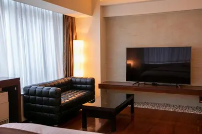 a hotel room with a couch chair and a flat screen tv at HOTEL APERTO (Adult Only) in Tokyo