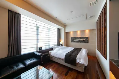 a bedroom with a bed and a couch at HOTEL APERTO (Adult Only) in Tokyo