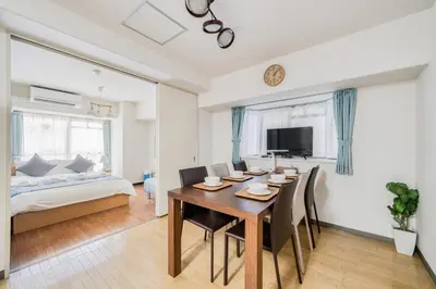 a dining room with a table and chairs and a bed at Park Residence Omori in Tokyo