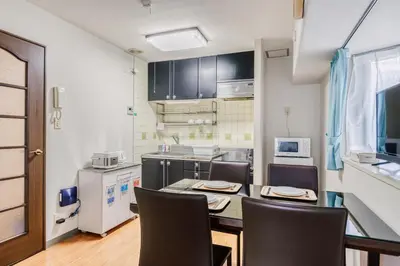 a kitchen with a table and chairs in a room at Park Residence Omori in Tokyo