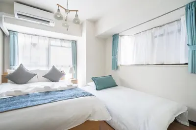 two beds in a room with two windows at Park Residence Omori in Tokyo