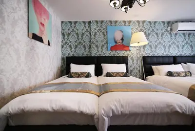 a bedroom with two beds and two pictures on the wall at SHINJUKU GLOBAL HOTEL in Tokyo