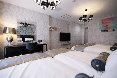 a bedroom with two beds and a desk and a computer at SHINJUKU GLOBAL HOTEL in Tokyo