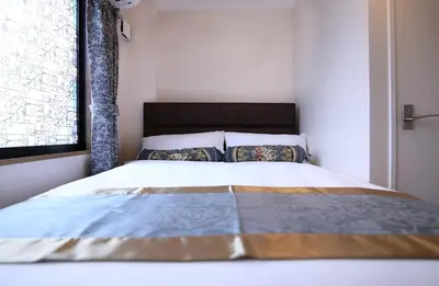 a bed in a small room with a window at SHINJUKU GLOBAL HOTEL in Tokyo