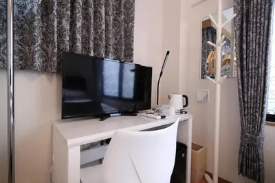 a white desk with a television on top of it at SHINJUKU GLOBAL HOTEL in Tokyo