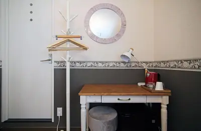 a room with a desk with a mirror and a lamp at SHINJUKU GLOBAL HOTEL in Tokyo