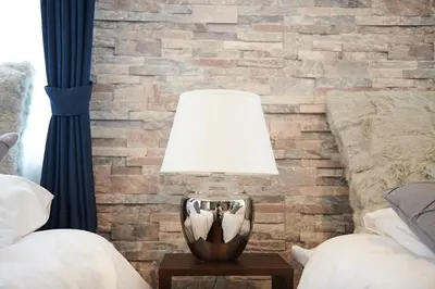 a lamp on a table in front of a brick wall at Ueno Residence Hotel Matsumoto in Tokyo