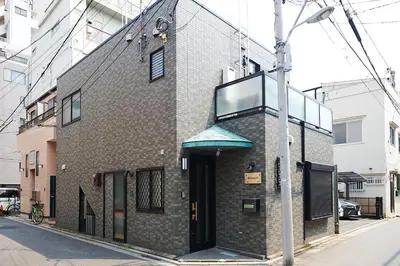a brick building on a street with a pole at Ueno Residence Hotel Matsumoto in Tokyo