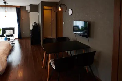 a living room with a table and chairs and a bed at Ueno Residence Hotel Matsumoto in Tokyo