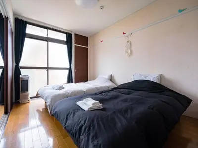 two beds in a room with a window at Murata Corpo 301 in Tokyo
