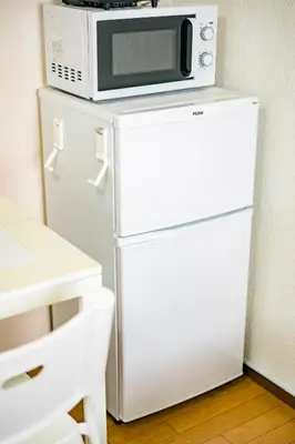 a microwave sitting on top of a white refrigerator at Murata Corpo 301 in Tokyo