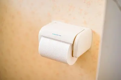a white soap dispenser hanging on a wall at Murata Corpo 301 in Tokyo
