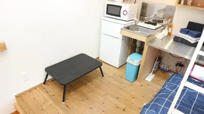 a small kitchen with a table and a refrigerator at Kanamechō detached house in Tokyo