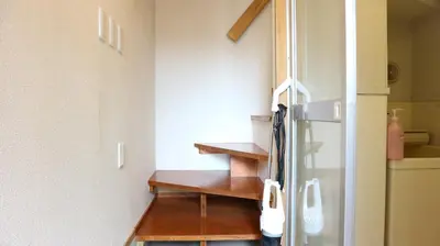 a room with a staircase next to a refrigerator at Kanamechō detached house in Tokyo