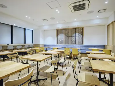an empty classroom with tables and chairs at hotel MONday Akihabara Asakusabashi in Tokyo