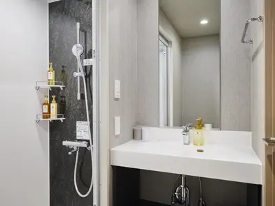 a bathroom with a white sink and a shower at hotel MONday Asakusa in Tokyo