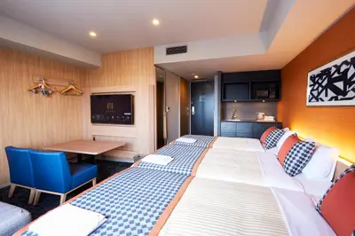 a hotel room with a large bed and a table at hotel MONday Asakusa in Tokyo