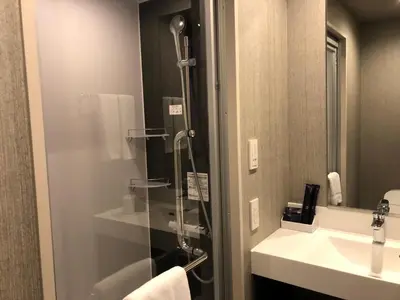 a bathroom with a shower and a sink at hotel MONday Asakusa in Tokyo