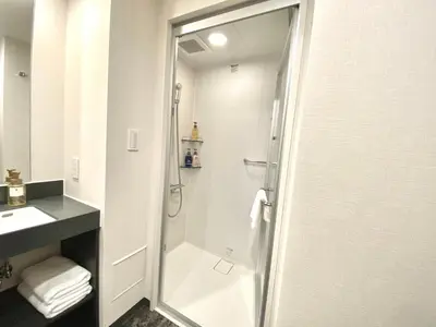 a bathroom with a shower and a sink at hotel MONday Premium Ueno Okachimachi in Tokyo