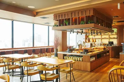 a restaurant with tables and chairs and windows at hotel MONday Premium Ueno Okachimachi in Tokyo