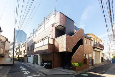 a brick building with a spiral staircase on a street at Cross Bridge Ikebukuro in Tokyo