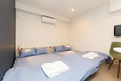 a bedroom with two beds with towels on them at Cross Bridge Ikebukuro in Tokyo