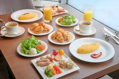 a table with plates of food and cups of coffee at InterContinental Tokyo Bay by IHG in Tokyo