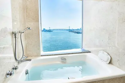 a bath tub with a large window in a bathroom at InterContinental Tokyo Bay by IHG in Tokyo