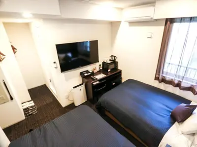 a hotel room with a bed and a television at HOTEL LiVEMAX Shinjuku EAST in Tokyo