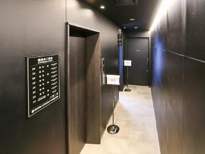 a room with a sign on the wall and a hallway at HOTEL LiVEMAX Nihonbashi Ningyocho in Tokyo