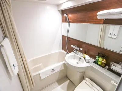 a small bathroom with a sink and a toilet at HOTEL LiVEMAX Tokyo Kanda-Ekimae in Tokyo