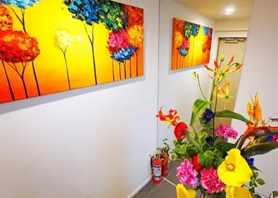 a room with three paintings on the wall with flowers at Stay Well & Give Well, Full Building in Asakusa in Tokyo