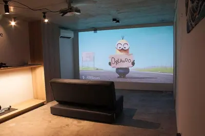 a large screen with a picture of a cake on a stage at Stay Well & Give Well, Full Building in Asakusa in Tokyo