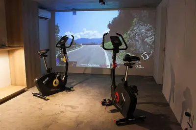 two exercise bikes in a room with a video screen at Stay Well & Give Well, Full Building in Asakusa in Tokyo