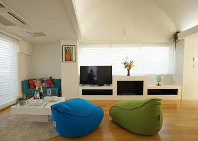 a living room with two blue chairs and a tv at Stay Well & Give Well, Full Building in Asakusa in Tokyo