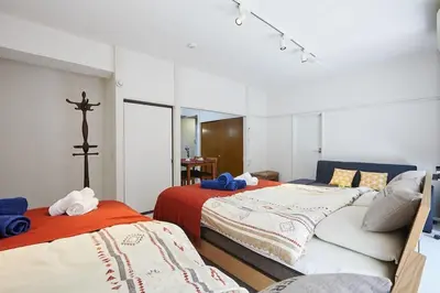 a bedroom with two beds and a cross on the wall at G&R House 102 in Tokyo